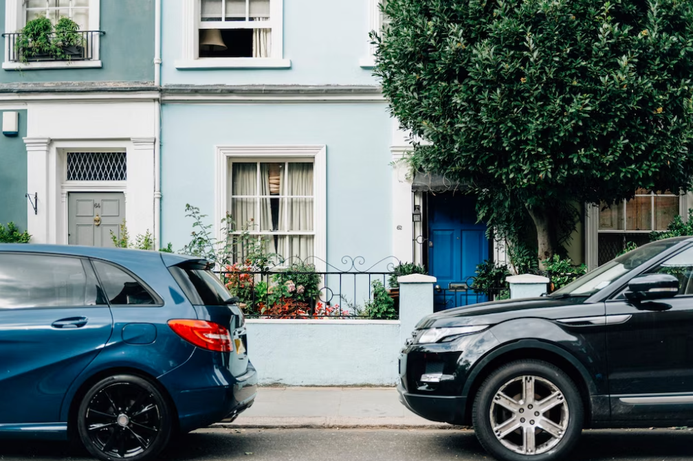 two parked cars in front of an apartment entrance